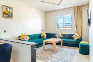 a living room with a blue couch and a table at 2 Voies Résidence in Dakhla