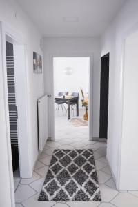 a white hallway with a black and white rug on the floor at Apartment Panoramablick Rhön by Interhome in Sandberg