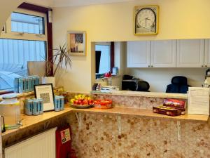 a kitchen with a counter with a clock on the wall at City Inn Express Hotel in London
