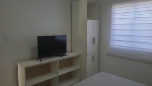 a living room with a flat screen tv on a shelf at casa reñaca sector jardín del mar in Viña del Mar