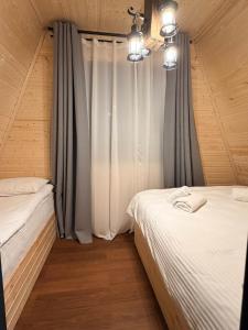 een slaapkamer met twee bedden en een raam bij WinterFell Mestia in Mestia