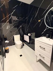 een badkamer met een wit toilet en een zwarte muur bij WinterFell Mestia in Mestia
