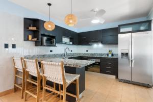 a kitchen with a counter and a refrigerator at Spacious Home with Private Pool & Covered Patio Near the Beach in Playa Flamingo