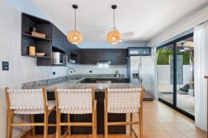 a kitchen with a large island with bar stools at Spacious Home with Private Pool & Covered Patio Near the Beach in Playa Flamingo