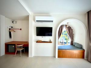 a bedroom with a bed with a window and a desk at Hidden Haven Resort Koh Lanta in Ko Lanta