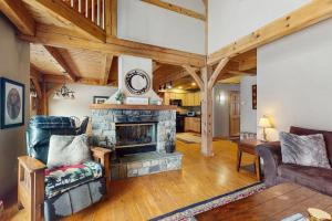 a living room with a stone fireplace and wooden ceilings at Grouse Lane 12C in Dover