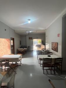 a room with tables and chairs and a room with tables at LD Hotel in Três Lagoas