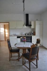 a kitchen with a table and chairs in it at Apartment am Waldesrand by Interhome in Schmallenberg