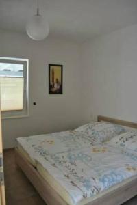 a bed in a bedroom with a picture on the wall at Apartment am Waldesrand by Interhome in Schmallenberg