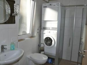 a bathroom with a washer and a toilet and a sink at Apartment am Waldesrand by Interhome in Schmallenberg