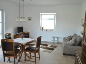 a living room with a table and a couch at Apartment am Waldesrand by Interhome in Schmallenberg