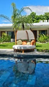 un letto accanto a una piscina accanto a una casa di Los Papyrus a Bahia