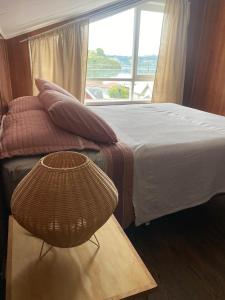 ein Schlafzimmer mit einem Bett und einem Fenster in der Unterkunft Raíces de Gamboa in Castro + 7 Fotos