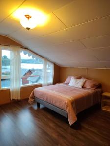 ein Schlafzimmer mit einem Bett und einem großen Fenster in der Unterkunft Raíces de Gamboa in Castro