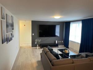 a living room with a couch and a flat screen tv at IQ apartments 3 in Ytri-Njarðvík