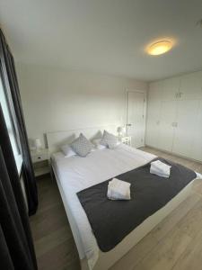 a bedroom with a large white bed with two pillows at IQ apartments 3 in Ytri-Njarðvík