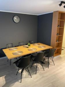 a table in a room with chairs and a clock at IQ apartments 3 in Ytri-Njarðvík +2 photos
