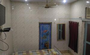 a room with a wall with a blue door at Goldy Guest House in Varanasi