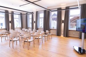 a room with rows of chairs and a flat screen tv at KurOase im Kloster in Bad Wörishofen