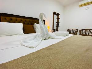 een bed met witte lakens en witte sokken erop bij lunar mirissa in Kamburugamuwa +17 foto's