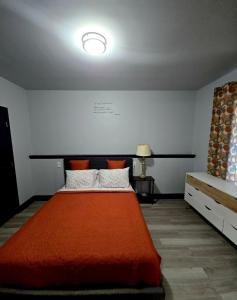 una camera da letto con un letto con una coperta rossa di St Joseph's Tavern a Dacula