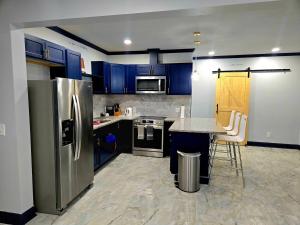 una cucina con elettrodomestici in acciaio inossidabile e armadi blu di St Joseph's Tavern a Dacula
