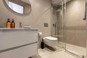 een badkamer met toilet en glazen douche bij Nesseus Lux Suites - Near Unic & EUC in Nicosia +84 foto's