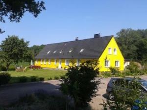 a yellow house with a black roof at Apartment in Dassow by Interhome in Feldhusen