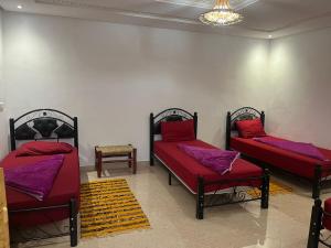 a room with two beds with red pillows on them at Taghazout surf in Tamraght Ouzdar