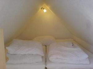 two stacks of white pillows in a small room at Apartment 3 by Interhome in Feldhusen