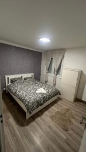 een slaapkamer met een bed met een zwart-wit dekbed bij Chambre Pour collocation in Thionville