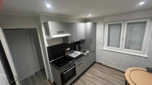 een kleine keuken met witte kasten en een fornuis bij Chambre Pour collocation in Thionville