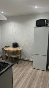een keuken met een tafel en een koelkast bij Chambre Pour collocation in Thionville