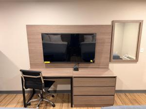 una scrivania con specchio e sedia in camera di Economy Suites Fort Smith a Fort Smith