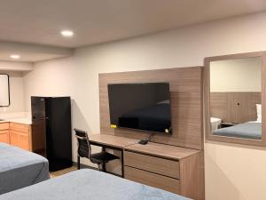 una camera con scrivania, TV e letto di Economy Suites Fort Smith a Fort Smith