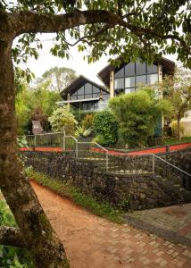 a house on top of a stone wall at Kood Heritage cottages in Vagamon