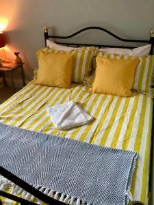 a yellow and white bed with a towel on it at Lorton Villa with a Log Burner in Saint Helens