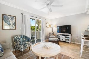 een woonkamer met een tafel en een tv bij Terrace Condo 6 in Holmes Beach