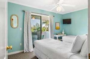 een slaapkamer met blauwe muren en een bed en een raam bij Terrace Condo 6 in Holmes Beach +54 foto's