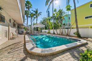 een zwembad voor een huis met palmbomen bij Terrace Condo 6 in Holmes Beach