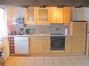 a kitchen with wooden cabinets and white appliances at Apartment Santa Maria by Interhome in Nettersheim