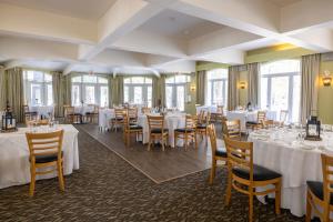 una sala da pranzo con tavoli e sedie bianchi di Sherwood Inn a Port Carling
