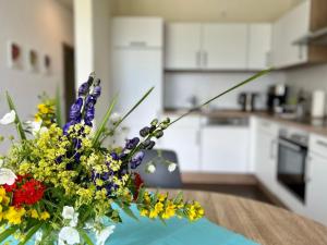 a vase of flowers on a table in a kitchen at Apartment Ober Langengarten by Interhome in Pittenbach