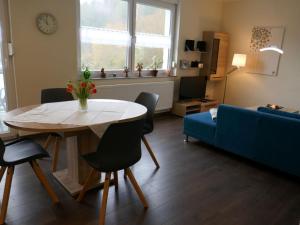 a living room with a table and a blue couch at Apartment Ober Langengarten by Interhome in Pittenbach