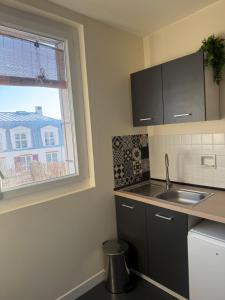 eine Küche mit Spüle und Fenster in der Unterkunft Peacefully place in Chelles