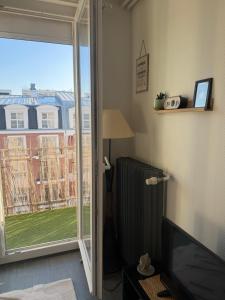 ein Wohnzimmer mit einer Glasschiebetür mit Fenster in der Unterkunft Peacefully place in Chelles