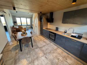 a kitchen with a table and a counter top at Lodges des Pontons - Cap Ouest - vue mer in Saint-Côme-de-Fresné