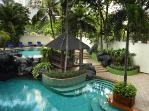 a swimming pool with a gazebo in a resort at Ascott Jakarta in Jakarta