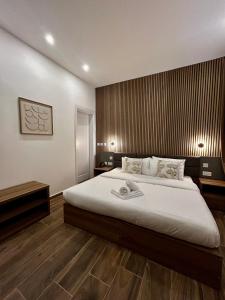 a bedroom with a large bed and a wooden floor at Tritoni Casa Kappuccini in Il-Furjana