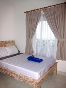 a bed in a room with a large window at Galang Kangin Bungalows in Amed